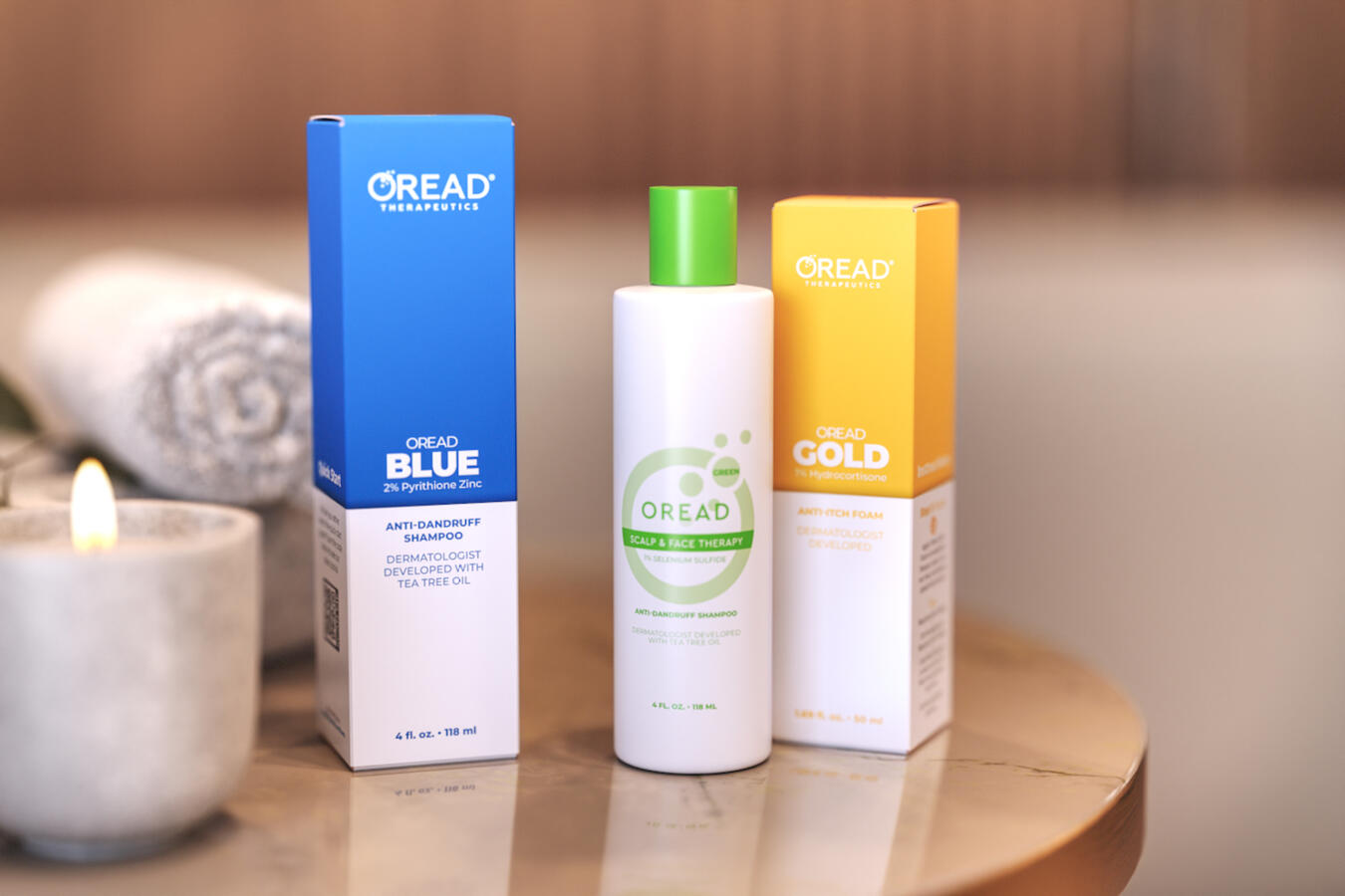 Oread Therapeutics anti-dandruff product line packaging: a blue box for Oread Blue shampoo, a white and green bottle for Oread Green shampoo, and a yellow box for Oread Gold anti-itch foam, shown on a bathroom counter.